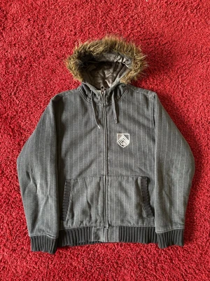 Quiksilver fur zip up hoodie - Quiksilver hoodie i storlek M. Pälskragen är avtagbar med dragkedja. Tröjan är fodrad och väldigt varm, nästan som en jacka. Mått: axelbredd - 49cm, längd - 66cm. Skriv för fler bilder och frågor!