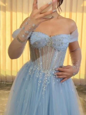 Ljusblå långklänning med glitter - Magisk ljusblå långklänning med glittriga detaljer och transparent liv. Klänningen har offshoulder ärmar, markerad byst och voluminös kjol i tyll. Perfekt för bal eller festliga tillfällen. Dekorerad med paljetter och gnistrande detaljer för en sagolik look. Priset kan diskuteras vid snabb affär :)🌸