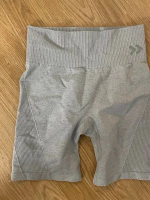 Grå ribbade cykelshorts/gymshorts - Snygga grå tight shorts  med ribbade detaljer i midjan och längs sidorna. De har medel midja och är tillverkade i ett stretchigt material som passar perfekt till träning eller chill.