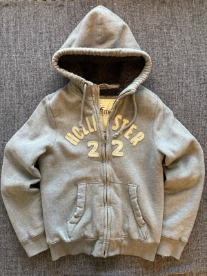 Hollister zip up ~  sällsynt modell - Sjukt eftertraktad Hollister zip-up hoodie ~ 2000’s modell som inte längre produceras | st S/true size | Rekomenderad längd mellan 170–180cm | färg grå med brun fodrad insida | klassisk passform | OBS kan gå ner lite i pris vid snabb affär! 🏄sliten design som ger extra vintage känsla 