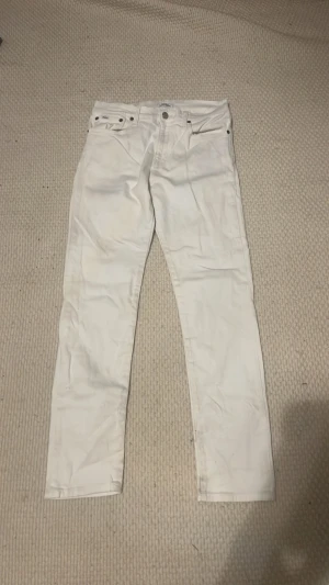 Ralph Lauren jeans - Snygga vita jeans i slim fit-modell med klassisk femficksdesign och raka ben. Jeansen har bälteshällor och knappgylf. Perfekta för dig som vill ha en fräsch och stilren look. Materialet känns mjukt och följsamt.
