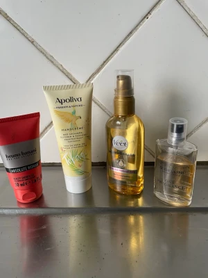Skönhetspaket med handkräm, olja & parfym - Ett paket med fyra skönhetsprodukter: Bruno Banani Absolute Woman body lotion i röd tub, Apoliva handkräm med sheasmör i gulvit tub, Veet hårborttagningsolja i genomskinlig pumpflaska och Celines parfym i transparent sprayflaska. Perfekt för dig som gillar att ta hand om dig.