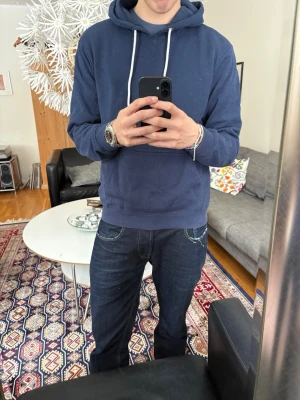 Mörkblå hoodie med vita snören - Snygg mörkblå hoodie med vita snören.