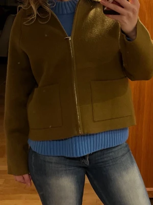 Olivgrön kort jacka med dragkedja - Säljer min olivgröna jacka från Zara🥰 jag var knappt använt jackan och därför är den i väldigt bra skick💕 den är perfekt till våren då den är varm för dom kyliga kvällarna och morgonar🥰jackan är liten i storleken, (så en storlek för liten)💕 om du har fler frågor är det bara till att fråga💕