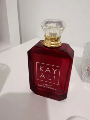 100 ml Kayali Lovefest Burning Cherry parfym - Kayali Lovefest Burning Cherry är en otrolig parfym! 🍒✨Den är sprillans ny, aldrig använd. Säljer pga råka beställa 2 och det är försent att lämna tillbaka😊