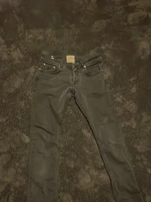 Svarta slim fit jeans från Morris  - Snygga svarta skinny jeans med klassisk femficksdesign och smal passform. Jeansen har stretchigt material för extra komfort och coola sömdetaljer på bakfickorna. Perfekta till en avslappnad streetstyle-look.