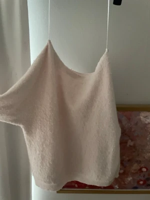 Ljusrosa stickad tröja - Mysig ljusrosa stickad tröja med rund halsringning och långa ärmar. Tröjan har ribbade muddar vid ärmslut och nederkant, vilket ger en snygg och avslappnad look. Perfekt för att hålla värmen under kyliga dagar.