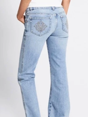 Ljusblå bootcut jeans med brodyr - Säljer ett par ljusblå bootcut jeans med snygg broderad detalj på bakfickan. Lågmidjade och storlek S short. Kontakta vid funderingar! 😁