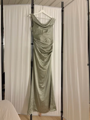Ljusgrön långklänning i satin - Fin  ljusgrön  klänning i glansigt satinmaterial från Meshki. Storlek S. Helt oanvänd. Nypris 2195kr. 