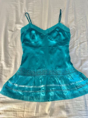 100% silk cami top - 100% silk cami top with lace trim and ruffles. The zipper pull is missing, but the zipper works well. You can easily attach a new one to the small remaining part. 