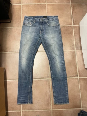 Tiger of Sweden jeans  - Snygga blå slim fit jeans med lätt slitna detaljer och klassisk femficksdesign. Jeansen har en ljus tvätt och raka ben, perfekta för en avslappnad och trendig look. Tillverkade i denim med en bekväm passform.