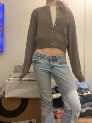 Brun cropped kofta med knappar - Säljer en brun cropped kofta med långa ärmar och knäppning framtill. Bra skick alldrig andvänt, köpt från Gina trico.