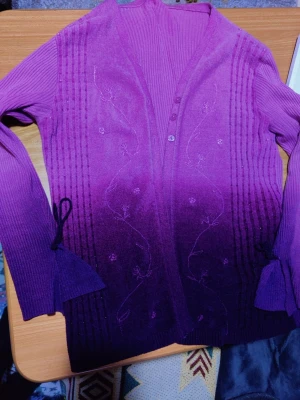 Lila kofta med broderi och knappar whimsigoth witchy goth  - Snygg lila kofta med ombre-effekt och diskreta blommiga broderier framtill. Koftan har ribbade detaljer, två knappar vid halsen och dekorativa band vid ärmsluten. Perfekt för dig som vill ha något unikt och färgstarkt i garderoben.