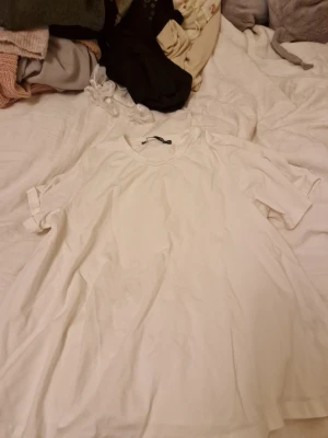 Vit basic t-shirt från 157 - En enkel vit t-shirt från 157 i storlek XS. T-shirten har rund halsringning och korta ärmar, perfekt för en clean och avslappnad stil. Tillverkad i mjuk bomull som känns skön mot huden.