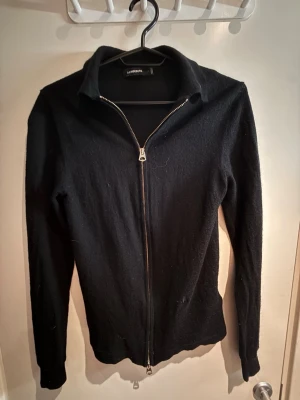 Svart ziptröja från A.L.C. - Snygg svart ziptröja från j Lindberg. med hel dragkedja framtill och krage. Tröjan har lång ärm och är tillverkad i ett mjukt, tunt stickat material som passar perfekt till lager på lager. Enkel och stilren design som funkar till det mesta. Den är S men den har blivit lite minskad i tvätten då passar som XS nypris 1200kr. Hör av er vid funderingar😊