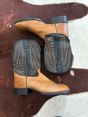 Tony Lama Cowboy Boots - snygga cowboy boots från tony lama med  klassiska broderade detaljer på skaftet. lite kortare skaft som är mer inriktad på arbete och vardags bruk samt gummi sula som håller bättre än skinnsulor. storlek har jag inte hittat stå någonstans men gissar på att det är runt 42,  söker främst byten mot andra skor/boots.