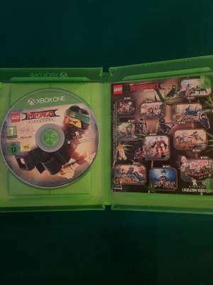 LEGO Ninjago Movie Videogame Xbox One - LEGO Ninjago Movie Videogame till Xbox One. Spelet har ett färgstarkt omslag med ninjafigurer i action och kommer i ett klassiskt grönt Xbox-fodral. Perfekt för dig som gillar äventyr och LEGO-universumet.