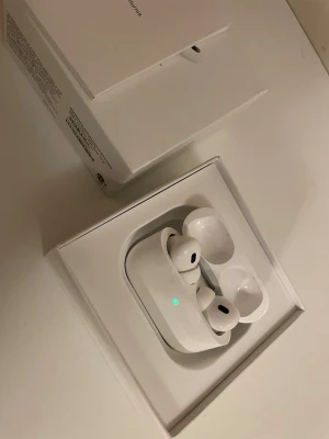 AirPods pro 2  - Säljer ett par vita Apple AirPods Pro med laddningsetui. Hörlurarna har en stilren och kompakt design med silikonproppar för bra passform. Perfekta för musik, samtal och träning. Levereras i originalförpackning.