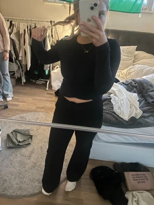 Svarta kostymbyxor med rak passform - Säljer ett par svarta kostymbyxor med rak passform och knappdetalj bak. Byxorna har hög midja och klassisk look, perfekta till en snygg outfit. Materialet ser ut att vara en mjuk och stretchig blandning som ger skön känsla hela dagen.