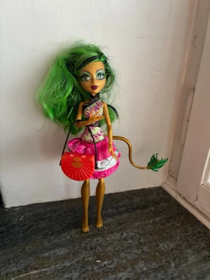 Monster High - Cool Monster High-docka med grönt hår, guldfärgad kropp och svans, ska vara en drake. Tyvärr inga skor eller accessoarer förutom väskan.