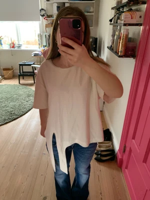 Vit topp med knytning framtill - Säljer en vit och gul randig topp med korta ärmar och unik knytning framtill. Toppen har en lös passform och är tillverkad i ett mjukt bomullsliknande material. Perfekt för dig som vill ha en enkel men ändå speciell topp till din garderob. 