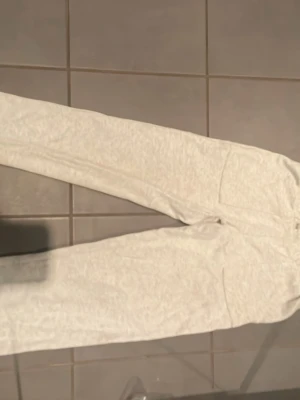Ljusgrå mjukisbyxor från 157 - Säljer ett par ljusgrå mjukisbyxor från 157 i storlek XS. Byxorna har resår i midjan och är gjorda i ett mjukt och bekvämt material, perfekta för chill dagar hemma. Klassisk rak passform och neutralt utseende som passar till det mesta.