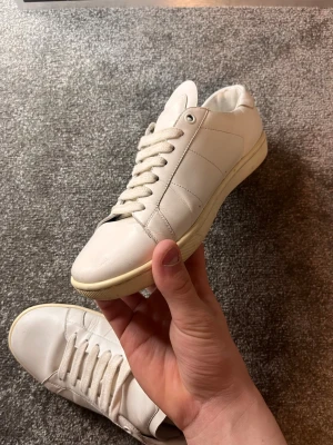 Saint Laurent, Kvitto finns!! - Saint Laurent skor i storlek 40 i färgen vit! Pris på dessa fina är 1299kr. Inga syndiga defekter, Enligt mig hur bra som helst! Hör av vid fler bilder och frågor. Tryck på bilderna för att få bättre kvalitet har hänt något! Gå in på profilen för mer skor i denna stilen och kläder. Rabatt vid köp flera plagg!