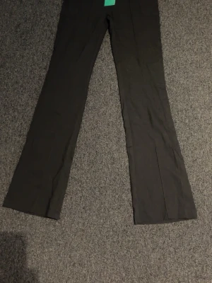 Svarta kostymbyxor från SHEIN - Snygga svarta kostymbyxor från SHEIN EZwear med raka ben och klassisk passform. Byxorna har diskreta pressveck och stängs med dragkedja och knapp framtill. Perfekta för en stilren look.