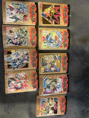 Yu-Gi-Oh! manga samlingsvolymer - Säljer ett gäng Yu-Gi-Oh! manga böcker med färgstarka omslag och klassiska animeillustrationer. Böckerna har svart rygg, guldiga detaljer och tydliga Yu-Gi-Oh!-loggor. Perfekt för dig som gillar manga, anime och samlar på klassiska serier. svensk text
