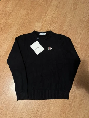Moncler Sweater - Helt oanvänd svart stickad tröja från Moncler i storlek xs. Tröjan är helt ny och har kvar taggen! Vid fler frågor är det bara att höra av sig🙌