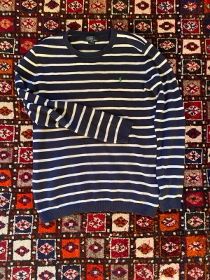 Marinblå randig stickad Ralph Lauren  - Snygg marinblå stickad tröja från Polo Ralph Lauren. Helt nytt skick och otroligt bra kvalitet! Hör av dig vid frågor om pris och annat! 