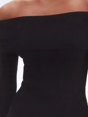 Svart ribbad offshoulder topp - Trendig svart ribbad topp med offshoulder-design och lång ärm. Sitter tight och har en stilren, minimalistisk look som passar perfekt till både jeans och kjol. Materialet är mjukt och följsamt för en bekväm känsla.