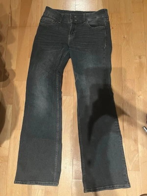 Lågmidjade bootcut jeans med fickor - Lågmidjade snygga svarta/ mörk gråa jeans från hm säljer för att jag har för många jeans, skriv om fler bilder önskas!