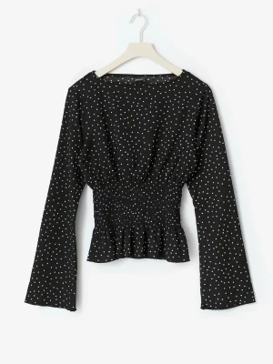 Svart prickig blus med smock - Trendig svart blus med vita små prickar och smockad midja som ger en snygg siluett. Blusen har långa ärmar och lätt utsvängd nederkant. Perfekt till jeans eller kjol för en cool och stilren look.
