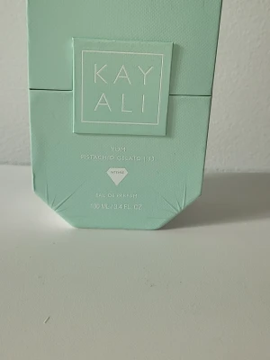 Kayali Yum Pistachio Gelato 33 EdP - Kayali Yum Pistachio Gelato 33 Eau de Parfum i en stilren, ljusgrön flaska med matchande kartong. Flaskan har en modern, kantig form och rymmer 100 ml. Doften är intensiv och inspirerad av pistageglass, perfekt för dig som gillar unika och söta parfymer.