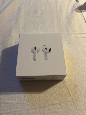 Apple AirPods 4  - Säljer ett par Apple AirPods 4  trådlösa. Hörlurarna är vita, har en stilren och kompakt design och levereras i originalförpackning. Perfekta för dig som vill ha en det lyxigt och med grymt ljud i ett smidigt format. OBS: Det är inget fel med dom ljudet är perfekt men det är bara några repor på själva skallet.