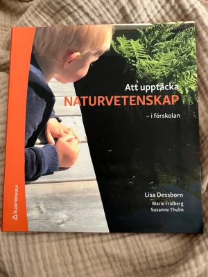 Att upptäcka naturvetenskap i förskolan - Kursbok om naturvetenskap i förskolan, skriven av Lisa Dessborn, Marie Fridberg och Susanne Thulin. Boken har ett färgstarkt omslag med orange och svart, och innehåller teman som fysik, ekologi och kemi. Perfekt för dig som pluggar till förskollärare.