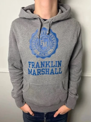 Grå hoodie från Franklin & Marshall - Säljer denna feta hoodien från Franklin & Marshall i storlek S. Passar perfekt till olika sköna outfits. Skick 9/10! Hör gärna av er om ni har några funderingar!