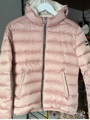 Ljusrosa pufferjacka från Colmar - Säljer min systers ljusrosa pufferjacka från Colmar med huva och dragkedja framtill. Jackan har två fickor med dragkedja och ett diskret logomärke på ärmen. Perfekt för kyliga dagar och ger en trendig look med sin quiltade design. Nypris:4599Kr Mitt pris:1499Kr