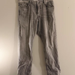 Grå raka jeans från Weekday - Snygga grå jeans från Jack N Jones  med rak passform och klassisk femficksdesign. Jeansen har normal midja, bälteshällor och stängs med dragkedja och knapp. Tillverkade i ett mjukt denimtyg som ger en avslappnad look.