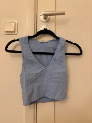 Ljusblå ribbad croppad linnetopp - Ljusblå croppad linnetopp med v-ringning och ribbad struktur. 