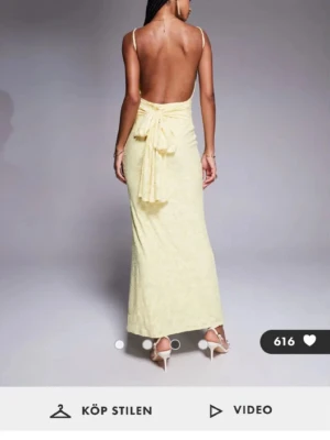 Ljusgul långklänning med öppen rygg - Supersnygg ljusgul långklänning från ASOS med smala axelband, öppen rygg och rosett bak🌼Klänningen har en figurnära passform och är gjord i ett blommigt mönstrat tyg. Den är aldrig använd, lappen sitter kvar. Säljer för returttden är slut. 