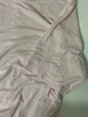 Ljusrosa basic t-shirt i bomull - En enkel och mjuk ljusrosa t-shirt med korta ärmar. Tillverkad i bomull för en skön och avslappnad känsla. Perfekt till jeans eller shorts för en clean och fräsch look.