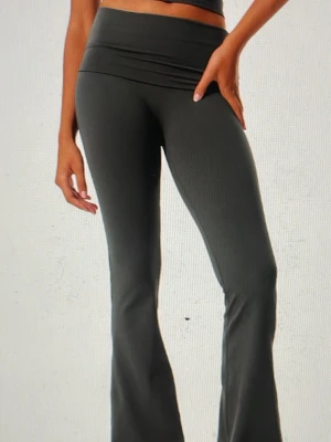 Mörkgrå ribbade bootcut leggings - Snygga mörkgrå leggings med ribbad struktur och bootcut-modell. Hög midja som sitter bekvämt och ger en smickrande siluett. Perfekta för dig som gillar en trendig och avslappnad stil. Materialet är stretchigt och följsamt.