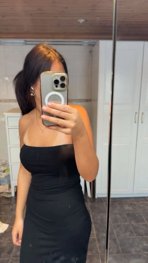 Svart axelbandslös lång klänning - Lång tube klänning från Gina, använd 1 gång.