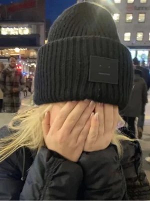 Acne mössa - Säljer en svart ribbstickad mössa från Acne Studios med den klassiska logotypen framtill. Mössan är i tjockt, mjukt material och har en bred uppvikt kant. Perfekt för att hålla värmen och ge en stilren look. Strl 56cm som motsvarar Onesize! 🫶🏻🫶🏻