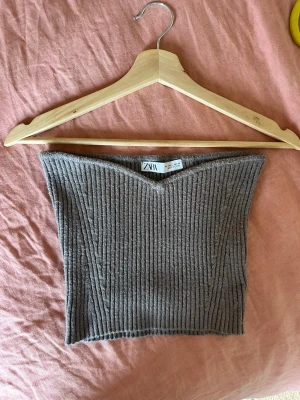 Stickad Tubtopp från Zara  - Tubtop ordentligt stickad från Zara. Himla härlig och skön. grå/ brun aktig färg. Storleken är L men köpt i Kina så skulle säga en M/S. Den är cropped. Bara använd en gång och behöver ny chans hos en ny ägare. 