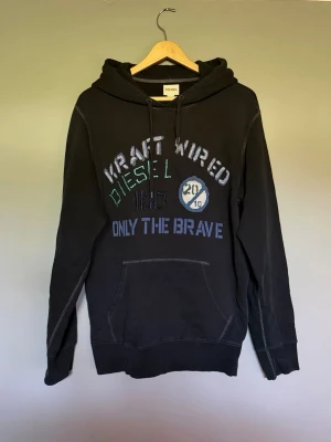 Svart Diesel hoodie - Snygg diesel hoodie med brodyr och tryck ifram, fint skick inga synliga slitningar eller liknande. Hör av dig om du har frågor! :)
