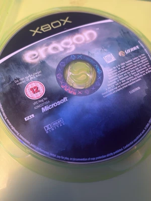 Eragon Xbox-spel - Eragon till Xbox är ett actionäventyrsspel baserat på filmen och boken. Skivan är svart med blå och lila detaljer, och har tydlig Xbox-logga samt märkning från Sierra. Spelet är märkt med 12-årsgräns och stödjer Dolby Digital.