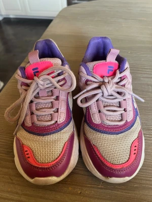 Fila sneakers i rosa och lila - Ett par Fila skor. Inte nya men fungerbar många år till. 